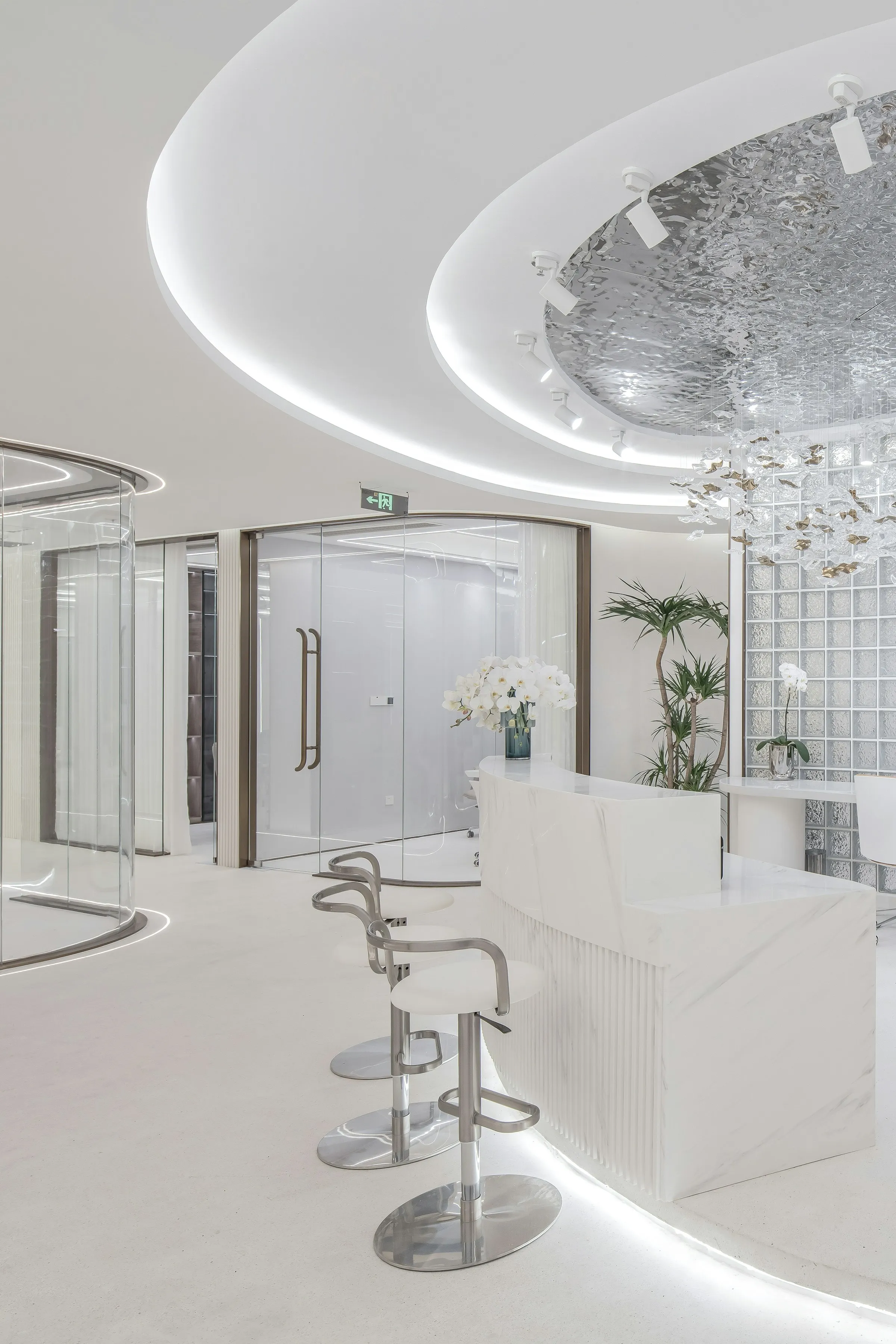 Curved white reception desk with LED cove lighting in a bright modern lobby